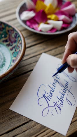 floral arrangement and calligraphy on wooden table