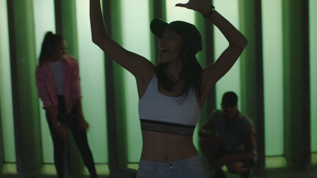 dancing woman young mixed race street dancer performing freestyle moves friends watching cheering enjoying dance in city at night