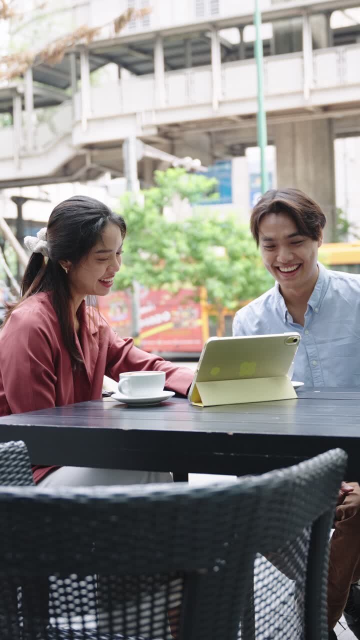 Friends enjoying coffee and technology at an outdoor cafe