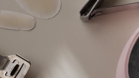 applying clear nail stickers with a nail clipper, close-up view of manicure tools
