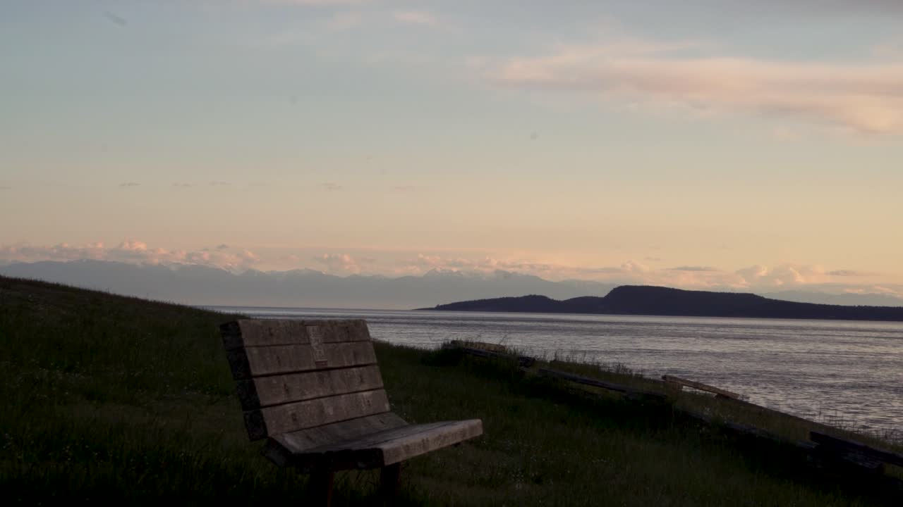 Wooden Bench At The Tranquil Shores Of Washington Park During Sunset In Anacortes, Washington USA. Tilt-up
