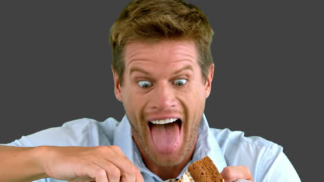 attractive man about to eat a cake on grey screen