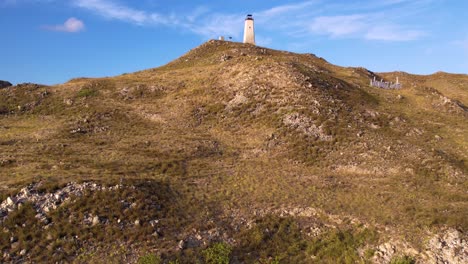 Luftaufnahme-Einer-Tropischen-Insel-Mit-Leuchtturm-Auf-Einem-Hügel,-Karibisches-Meer-Im-Hintergrund