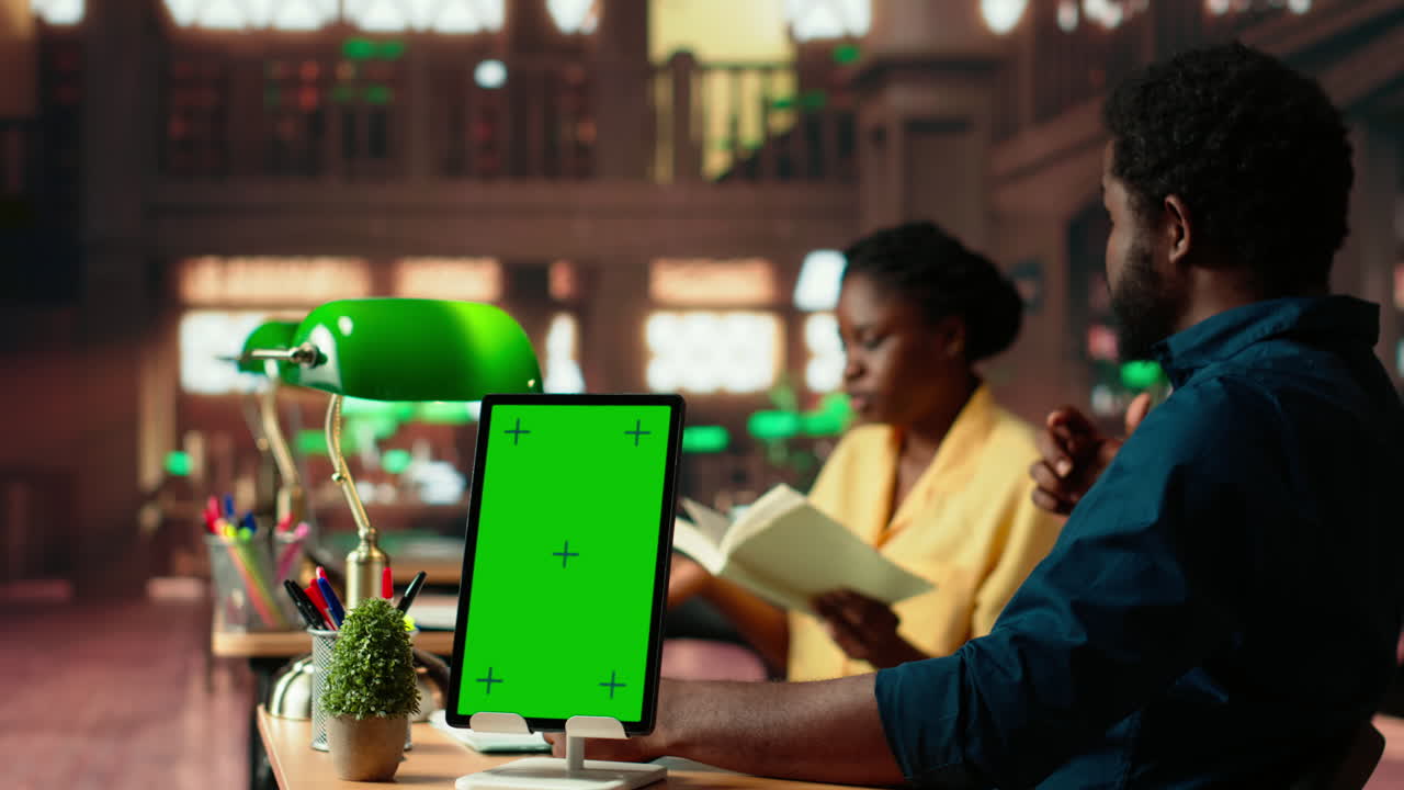 equipo afroamericano estudiando para exámenes junto a la pantalla de la llave chroma