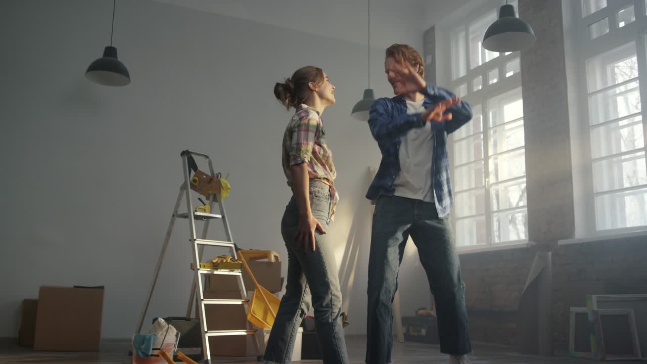 счастливая семья празднует в квартире. мужчина кружит женщину в руках в помещении.