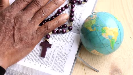 praying to god with hand on bible with cross and globe background with people stock footage