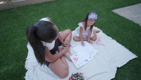 mother and daughter drawing together in the garden