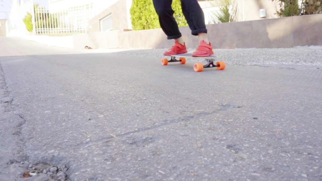 Young man in red sneakers skating in the street
