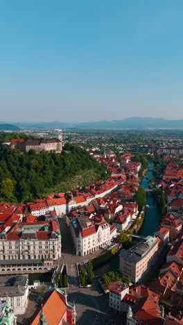 aerial vertical shot of ljubljana city center in slovenia, old town district and ljubljana castle on hill
