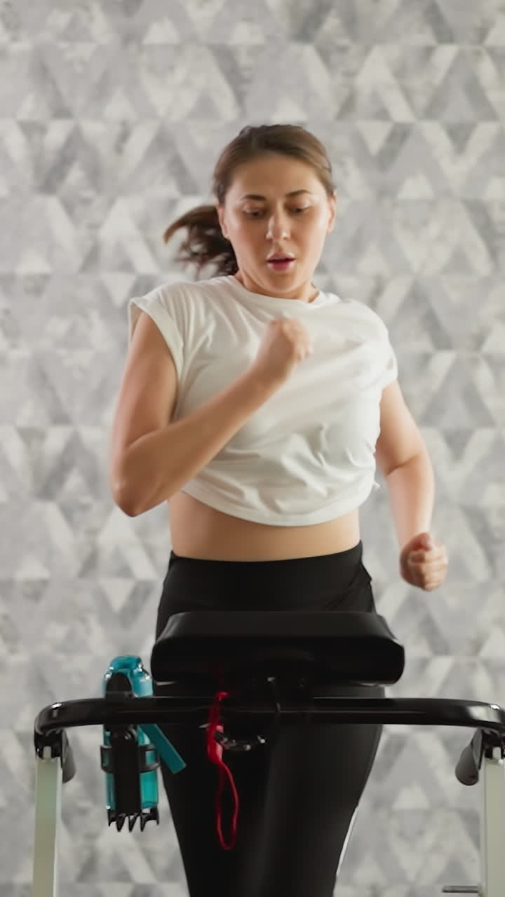 mujer corre rápido en la pista de cinta de correr en casa. mujer deportiva diligente hace ejercicios con entrenador automático en entrenamiento cardio intenso. suministros de entrenamiento de fitness