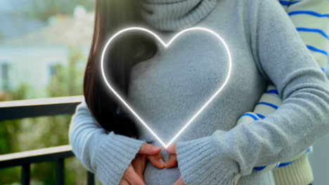 animación de corazón de neón sobre feliz pareja diversa abrazando