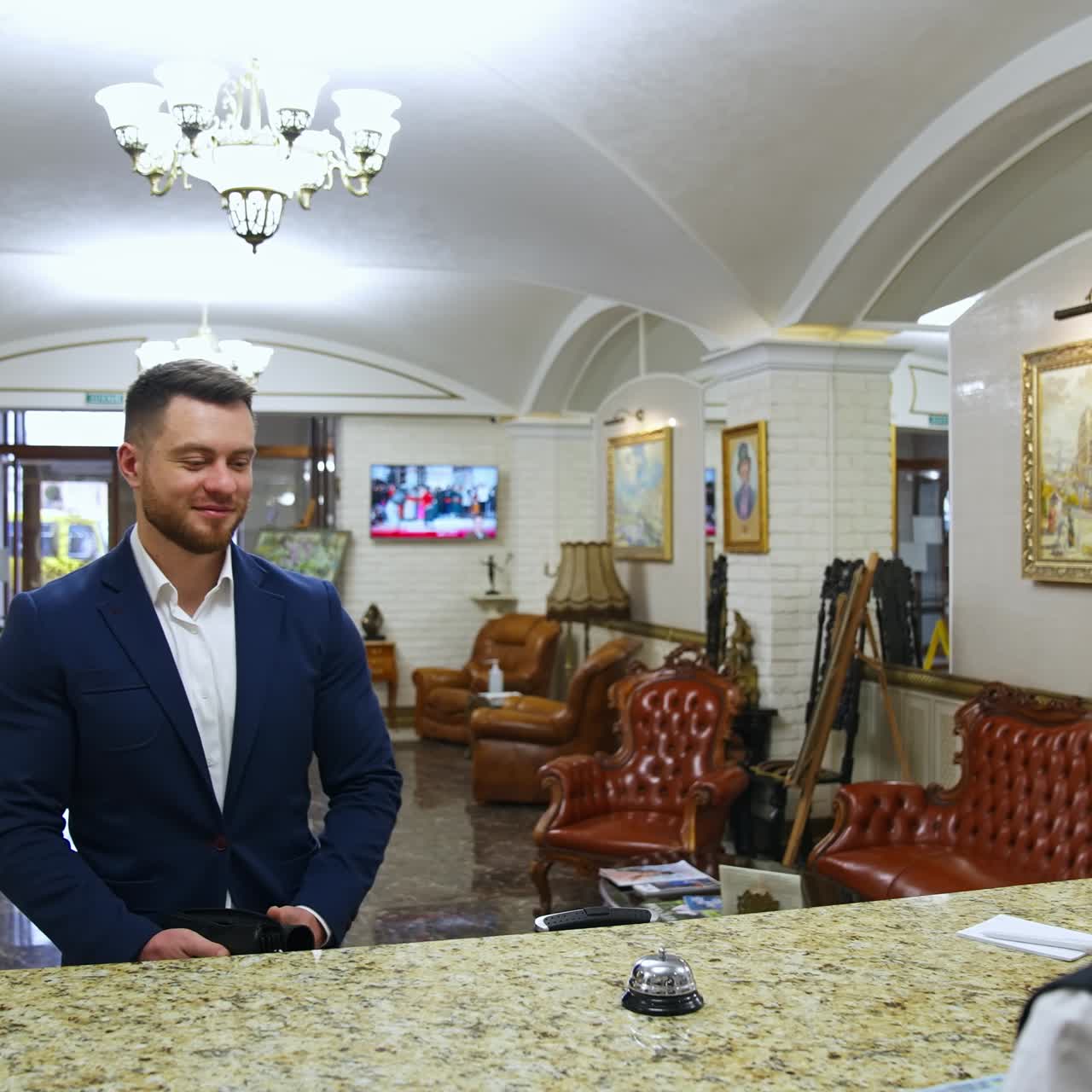 Young businessman at hotel reception. Young man near reception desk in hotel