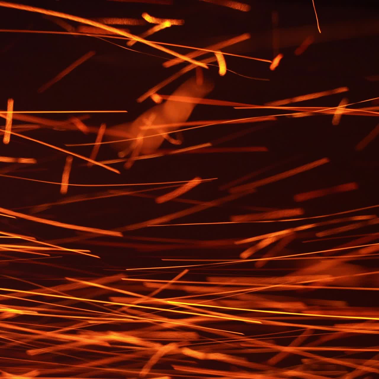 Red hot sparkles of fire flying horizontally at a very fast speed. Orange particles isolated on the black background