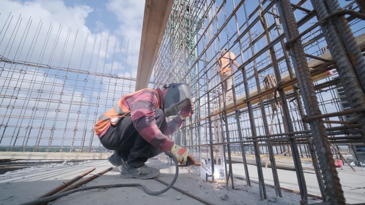 trabajador de la construcción que soldaba barras de refuerzo metálicas para el vertido de estructuras monolíticas