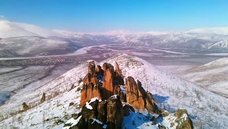 montañas rocosas en invierno contra un cielo azul en tiempo soleado de un dron 4k