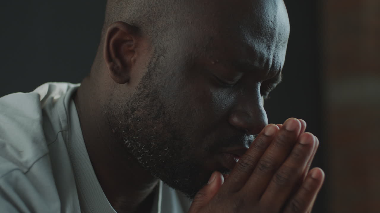 African American Man Praying with Eyes Closed and Palms Together