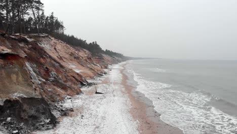 toma aérea de olas rompiendo en la playa de arena de ustka en invierno