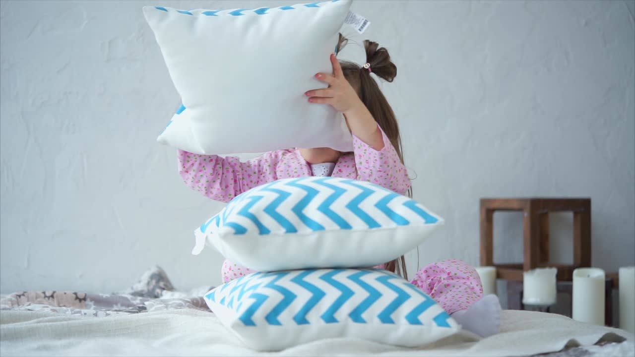 Child playing with pillows