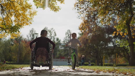 young mommy in wheelchair rests with daughter in park