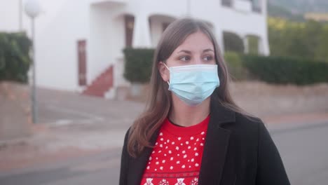 girl wearing a surgical mask in the street and looking around