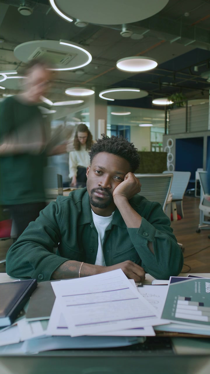 Timelapse of Unmotivated Black Businessman Sitting at Desk Piled with Paperwork