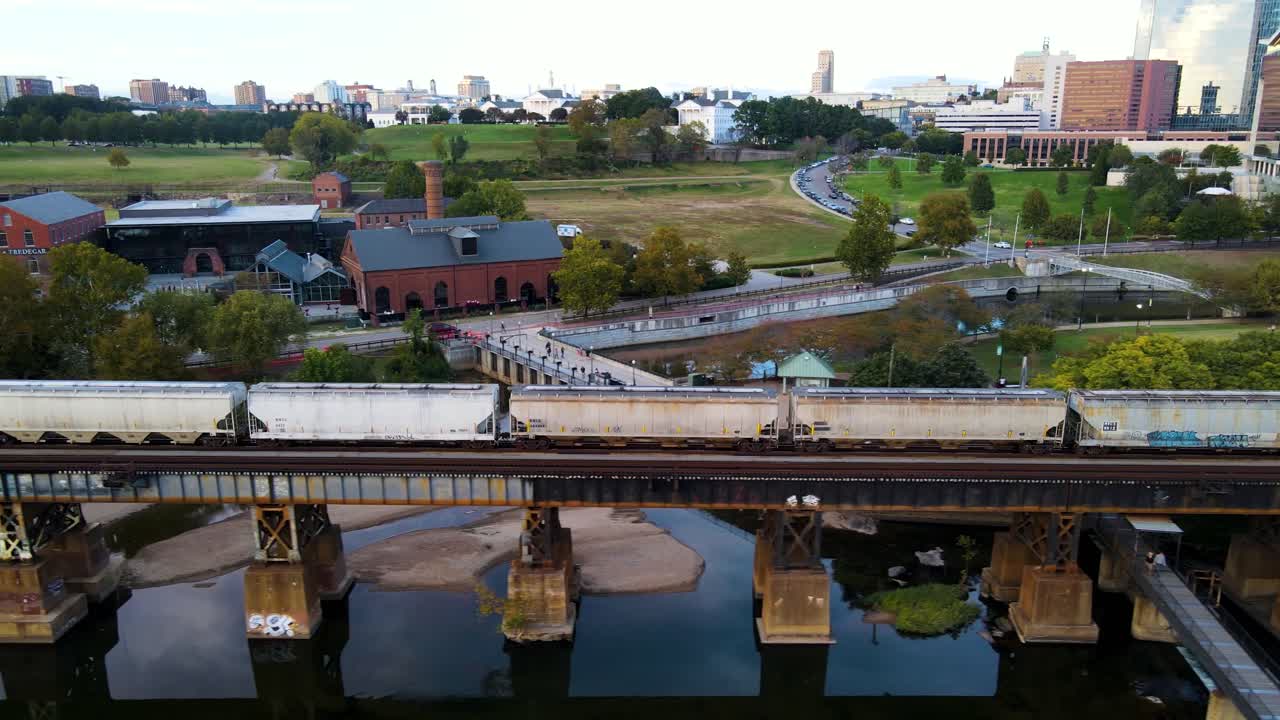 tren que viaja en la pintoresca orilla del río en richmond, virginia | vista aérea de seguimiento lateral | verano 2021