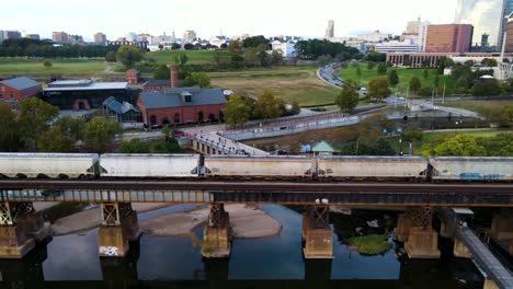 train traveling on scenic riverfront in richmond, virginia | aerial side tracking view | summer 2021