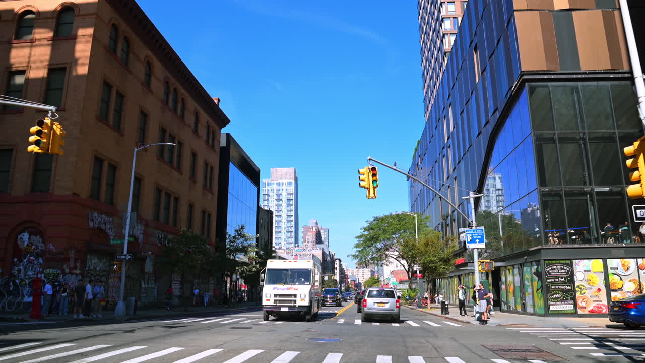 Nowy Jork, USA, 28 października 2025: Widok ulicy na Manhattanie. Miejska ulica z samochodami, drzewami i budynkami pod błękitnym niebem na Manhattanie