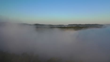 misty morning landscape over river and forest