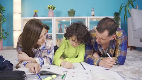 un niño de familia feliz besa a sus padres que lo ayudan con sus lecciones y los ama mucho.