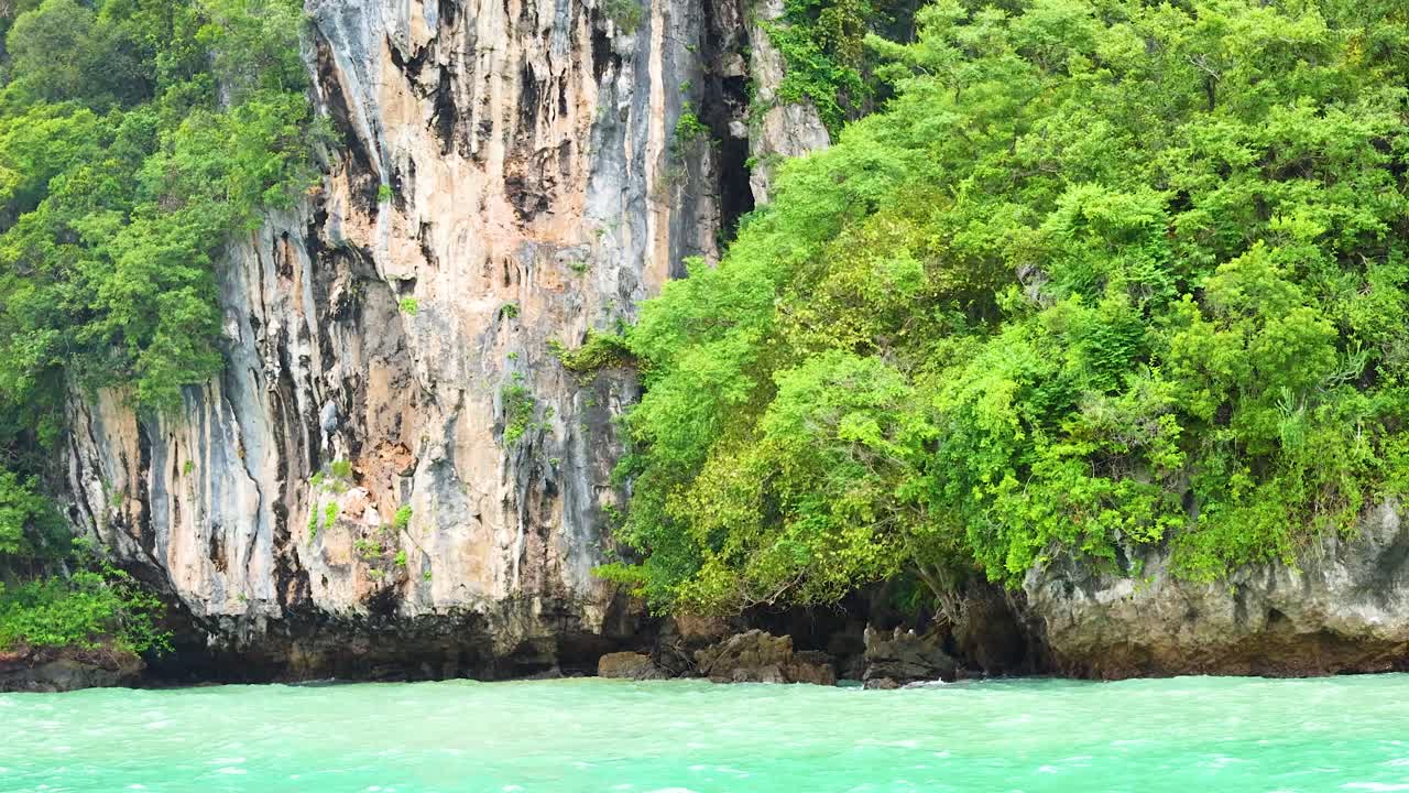 Vegetazione lussureggiante e scogliere bagnate da acque turchesi a Krabi, Thailandia.