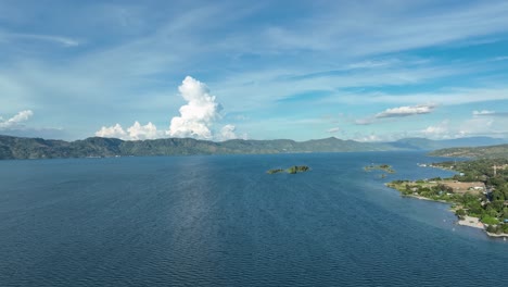 Lake-toba's-north-coast-in-sumatra,-indonesia-with-clouds-and-calm-waters,-aerial-view