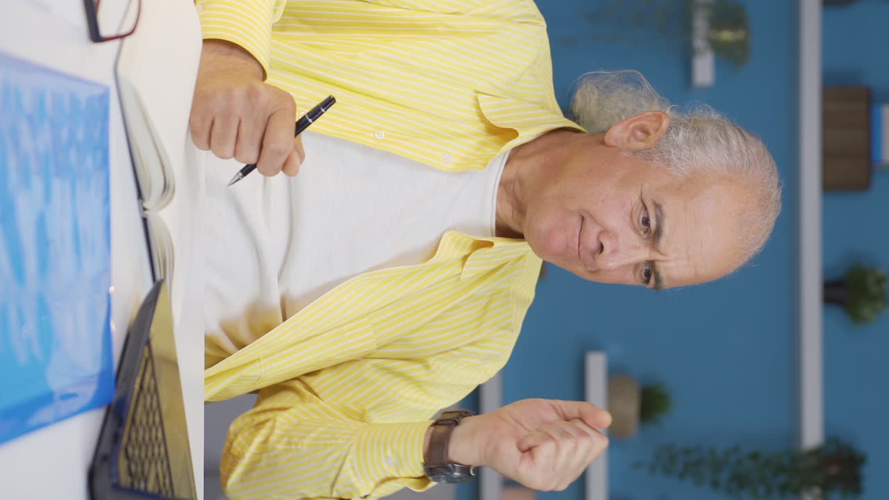 홈 오피스 근로자 노인이 성공하는 수직 비디오.