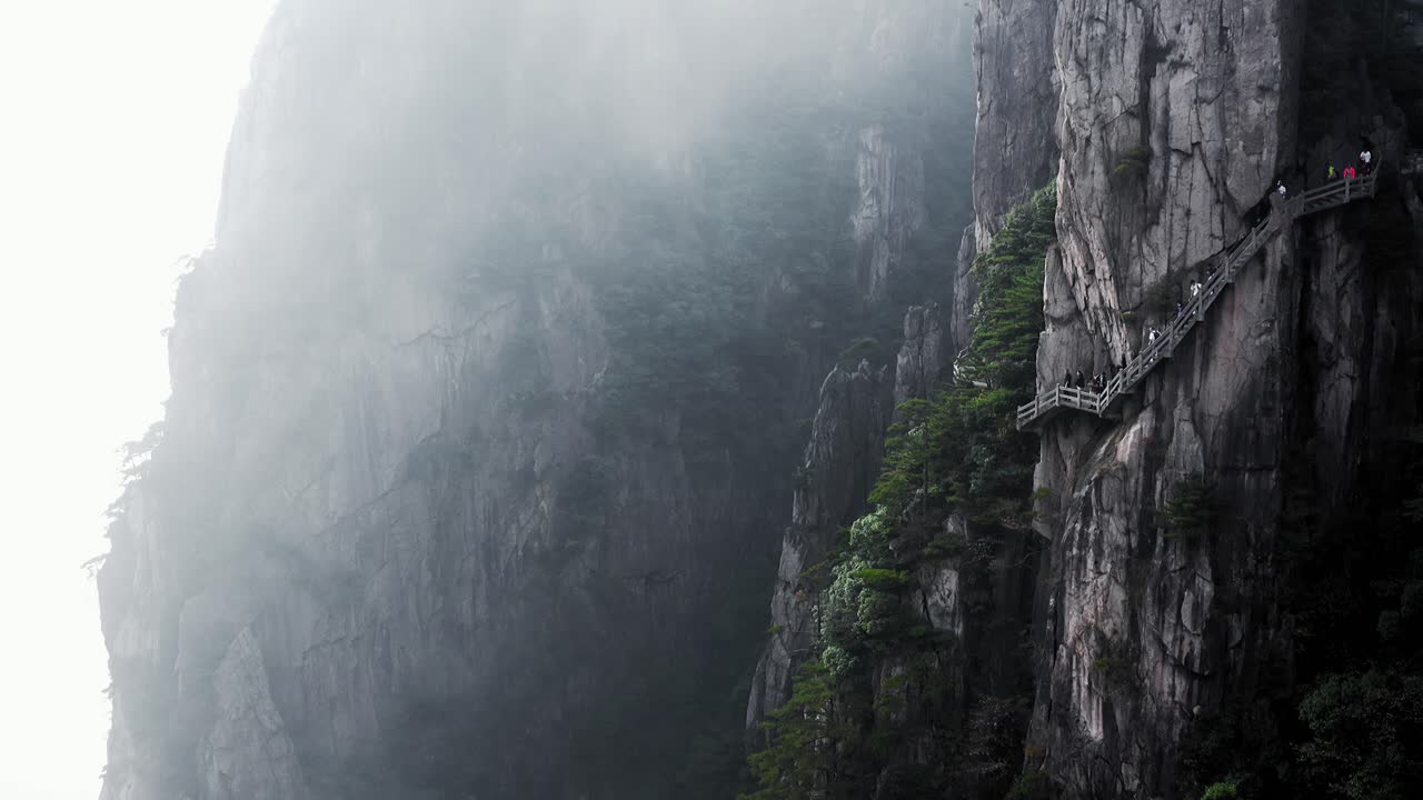 Breathtaking Hike on Cliffside Path Through Misty Mountains