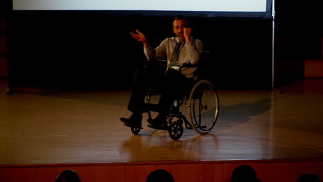 hombre de negocios caucásico maduro discapacitado hablando en un seminario de negocios en el auditorio 4k