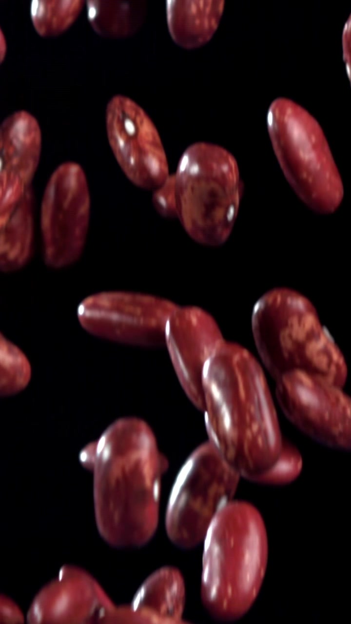 Red Kidney Beans Falling in Slow Motion on Black Background