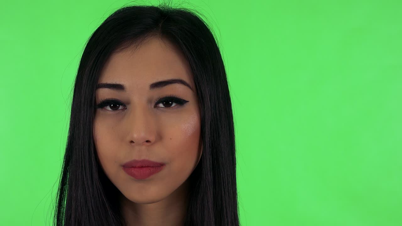 매력적인 젊은 아시아 여성이 카메라를 쳐다본다 ( 심각한 얼굴) - 그린 스크린 스튜디오 - 클로즈업