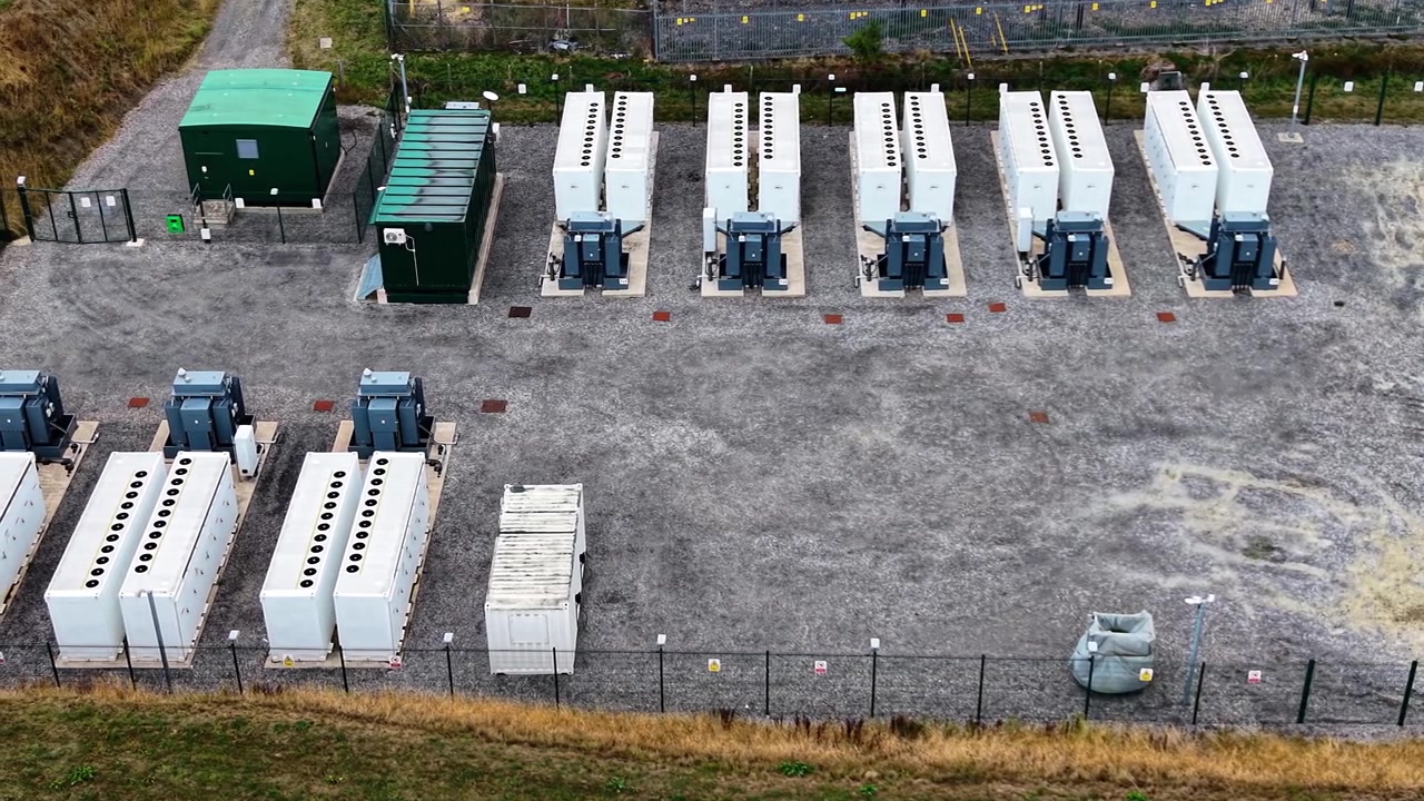 Slow Sideways Aerial of BESS Battery Energy Storage System near Electrical Substation in UK. Modern Lithium-ion Batteries Storing Power.
