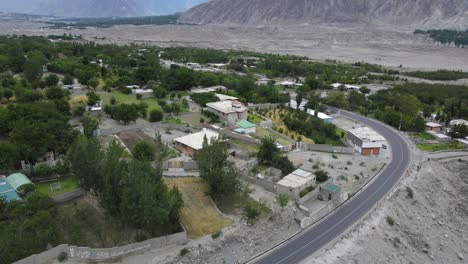 aerial view of village in hunza valley, pakistan, road traffic and homes in highlands