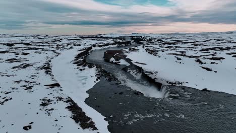 high above selfoss waterfall, iceland, an orbiting drone shot reveals the cascading waters framed by rugged icelandic terrain