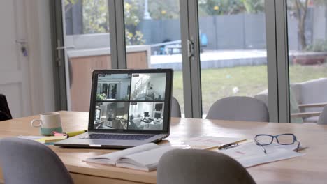 Laptop-on-dining-table-showing-four-home-security-camera-views,-slow-motion