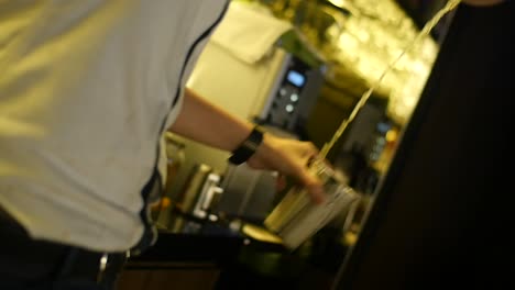 Cocktail-being-mixed-between-two-stainless-steel-cups-by-professional-bartender-in-slow-motion-close-up-shot