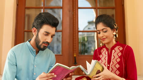 portrait of indian couple reading books and smiling