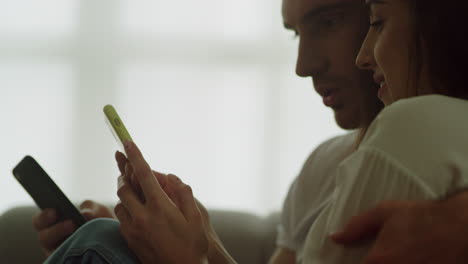 pareja joven usando teléfonos móviles en casa