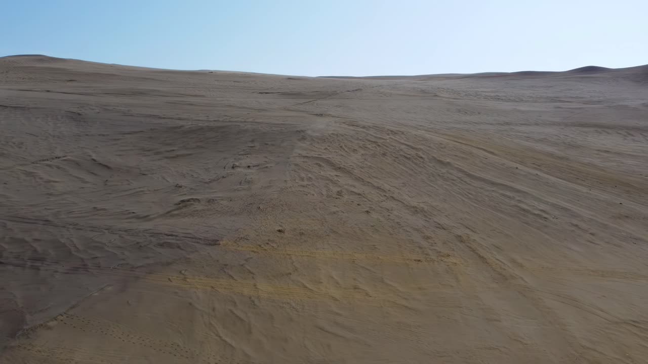 Desert land landscape drone aerial over arid soil dunes skyline clear sky