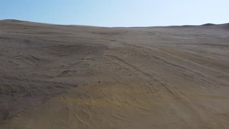desert land landscape drone aerial over arid soil dunes skyline clear sky