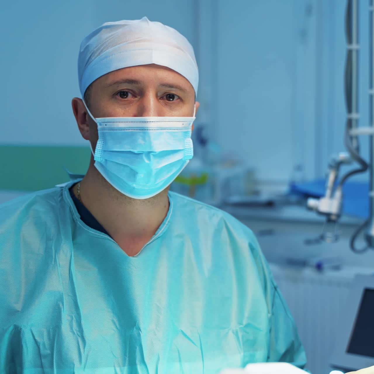 Plastic surgeon talking on camera. Professional doctor in medical uniform and mask doing a blepharoplasty. Portrait of a medical specialist in the operating room.
