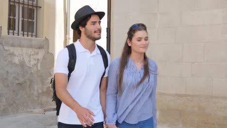 cheerful young couple on cultural weekend city trip discovering together historical european city in summer