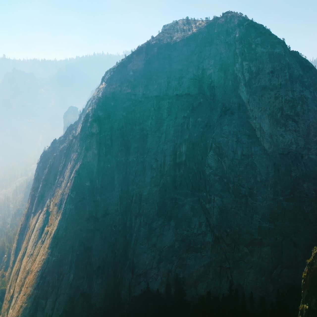 Bare cliff rock of Yosemite National Park, California, USA. Deep haze covering the horizon at backdrop