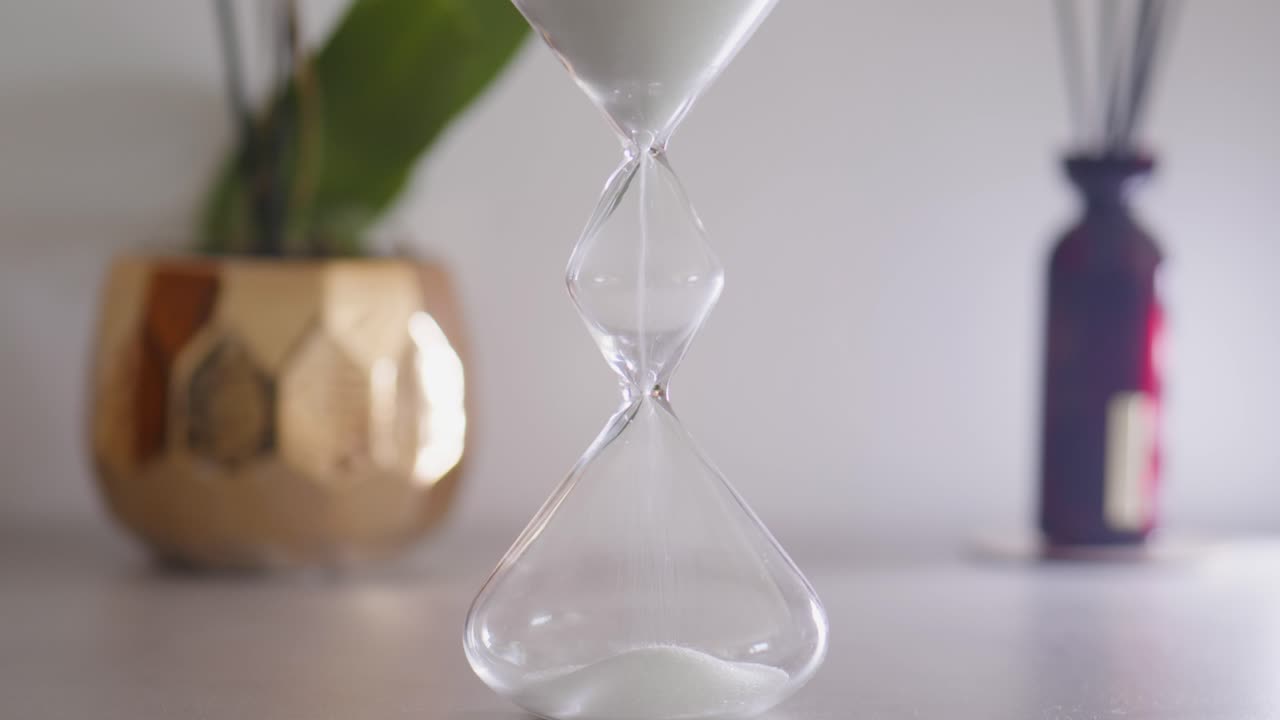 Hourglass with falling sand in relaxing scenery
